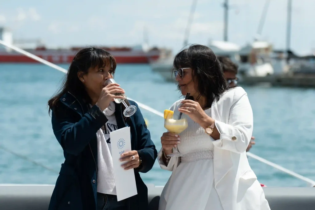 Dos pasajeras celebrando un evento de empresa a bordo de uno de nuestros catamaranes.