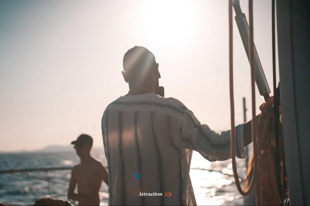 Pasajero a bordo de un catamarán de Attraction Catamarans, observando el horizonte con el sol brillante. Destaca la experiencia premium desde el mar para disfrutar del eclipse solar en Mallorca 2026.
