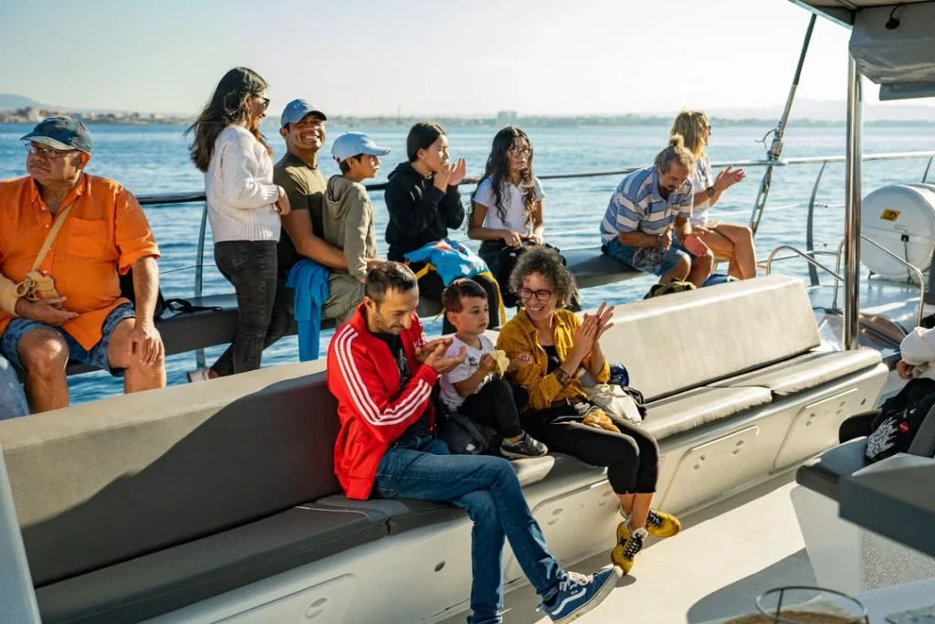 Familia y amigos disfrutando de un paseo en catamarán con sol. Un plan perfecto en Mallorca en el Puente de Diciembre.