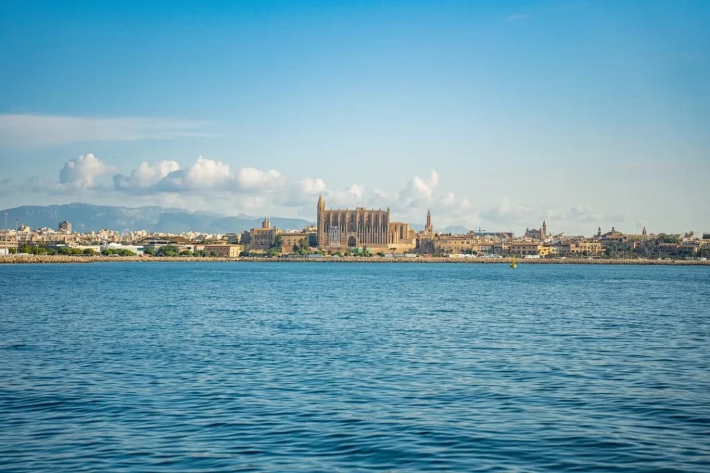 Vista panorámica desde el mar de la Catedral de Mallorca y la ciudad de Palma bajo un cielo azul, ideal para visitar en el puente.